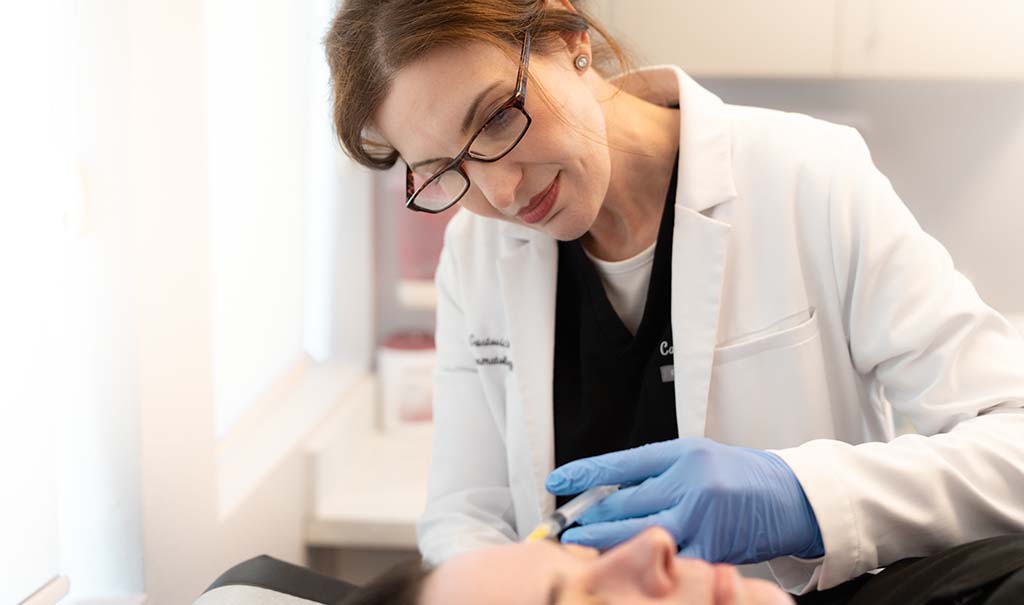 Dr. Carla Gustovich performing an injection in clinic at magnolia dermatology